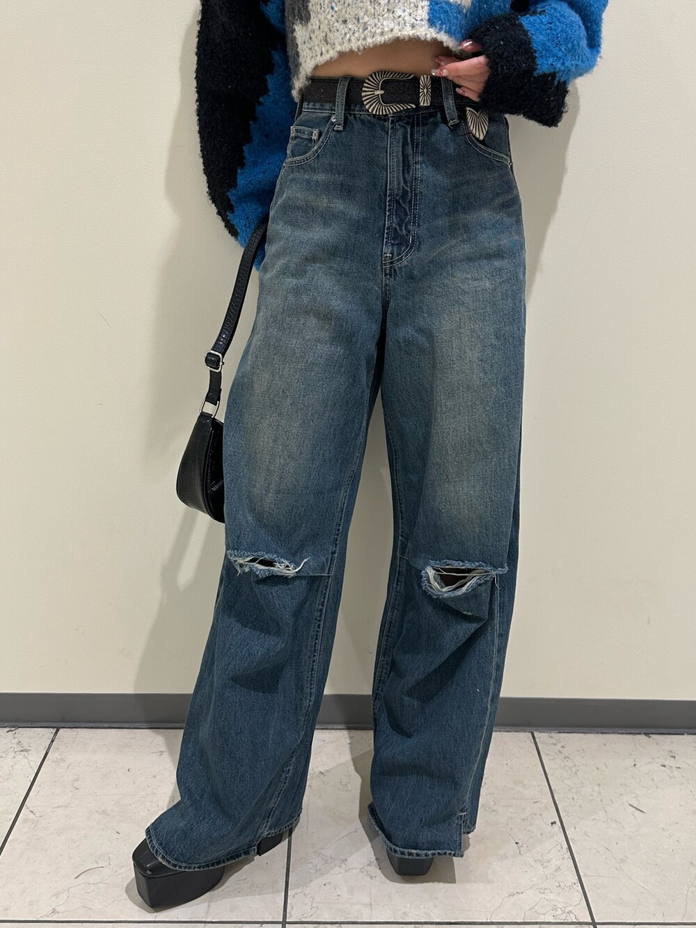 ブルー系のデニムパンツ、ブラック系のショルダーバッグ、ブラック系のブーツを着用したレディースの冬コーディネートの8枚目の写真