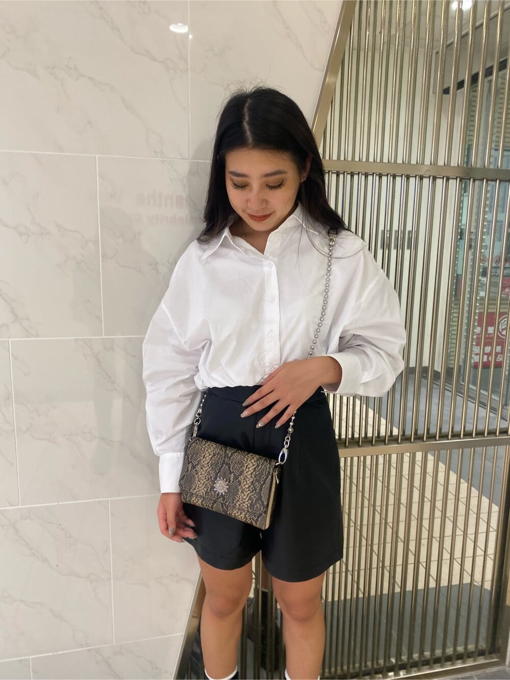 ブラック系のその他パンツ、ブラック系のブーツ、ホワイト系のシャツ/ブラウスを着用したレディースの夏コーディネートの3枚目の写真