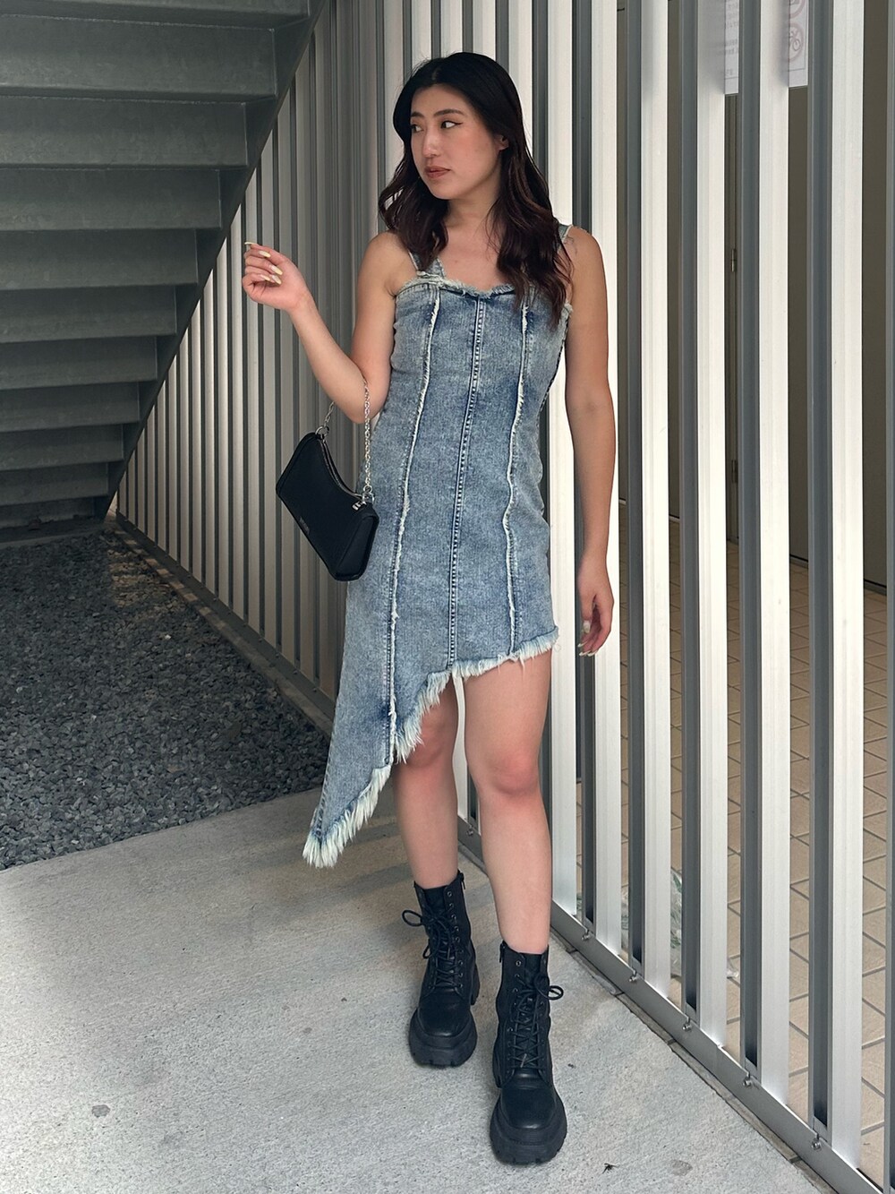 ブラック系のショルダーバッグ、ブラック系のブーツ、ブルー系のワンピースを着用したレディースの夏コーディネートの2枚目の写真