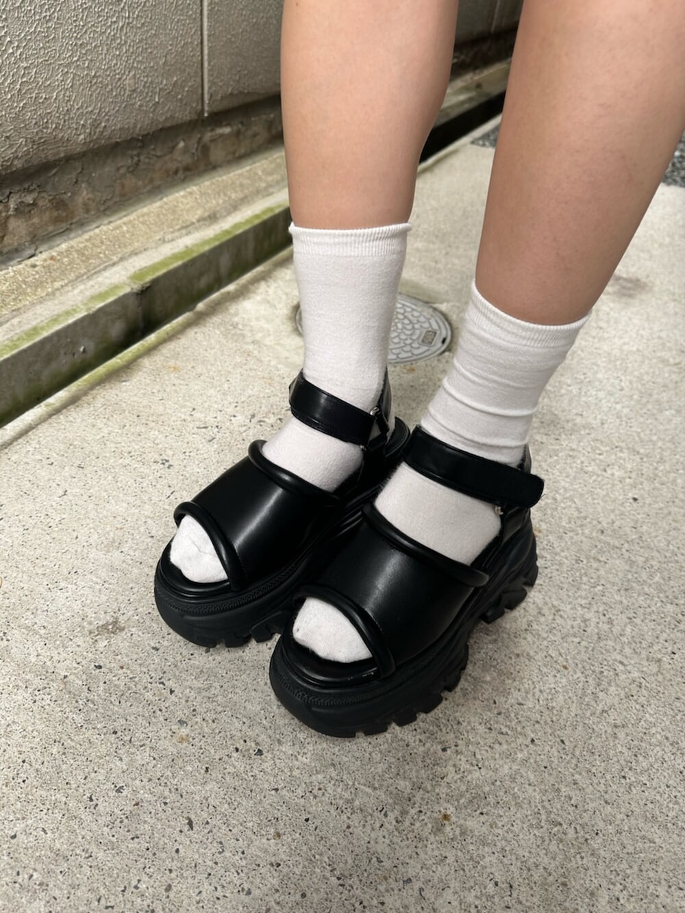 ブラック系のサンダル、ブルー系のキャミソール、ブルー系のデニムスカートを着用したレディースの夏コーディネートの7枚目の写真