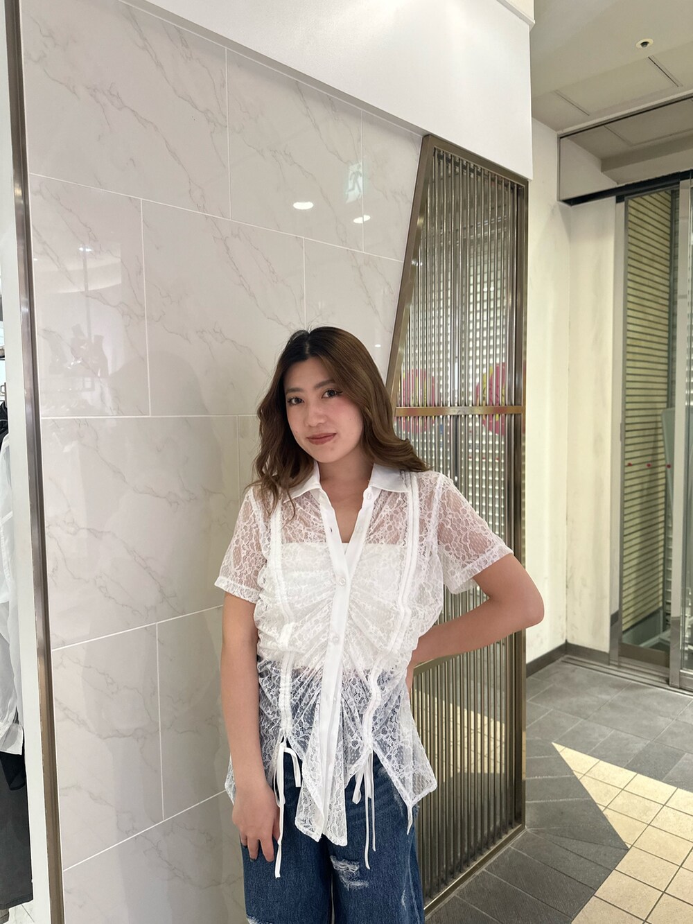 ホワイト系のシャツ/ブラウス、ブルー系のデニムパンツ、ブラック系のサンダルを着用したレディースの春コーディネートの4枚目の写真