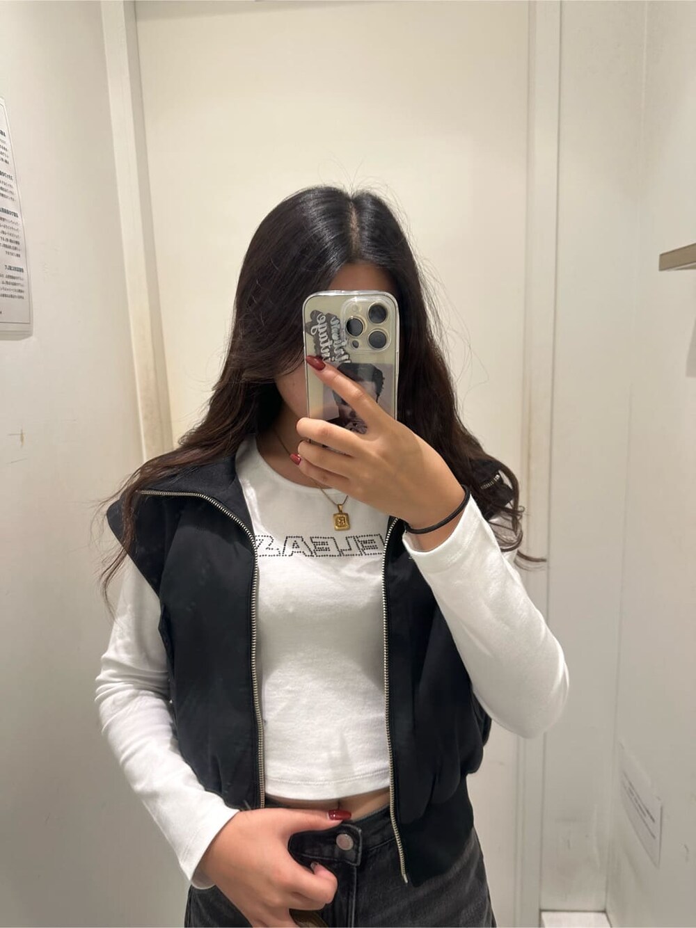 ブラック系のMA-1、ブラウン系のハンドバッグ、ブラック系のデニムパンツを着用したレディースの秋コーディネートの3枚目の写真