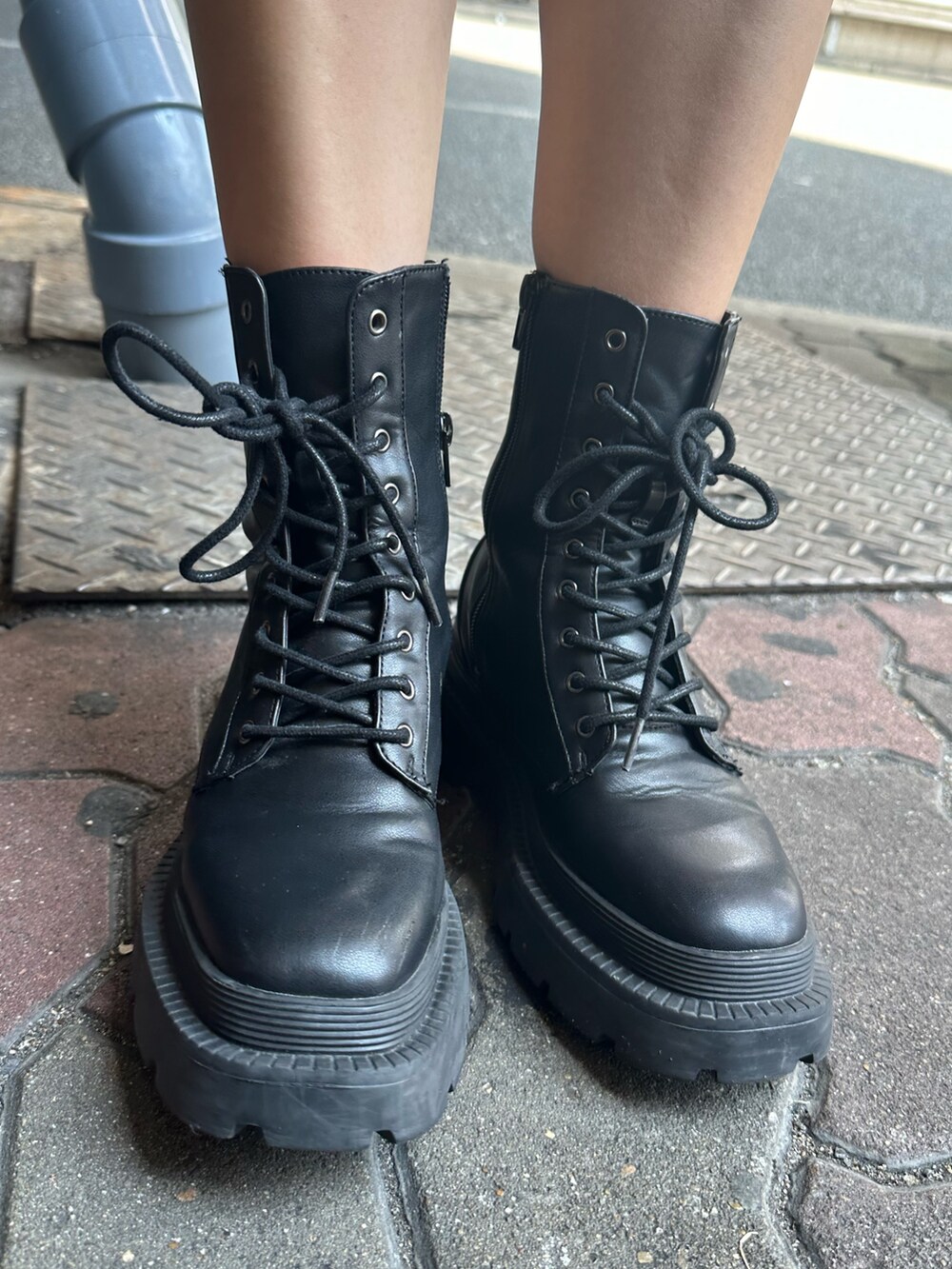 ホワイト系のTシャツ/カットソー、グレー系のスカート、ブラック系のブーツを着用したレディースの秋コーディネートの10枚目の写真