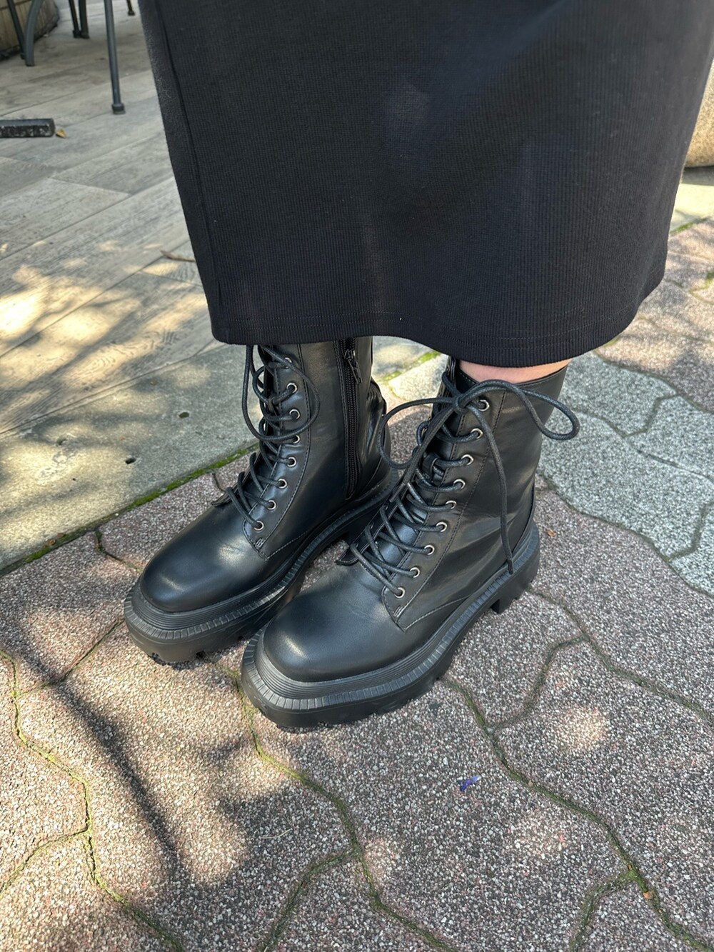 ブラック系のワンピース、ブラック系のブーツ、ホワイト系のキャップを着用したレディースの春コーディネートの9枚目の写真