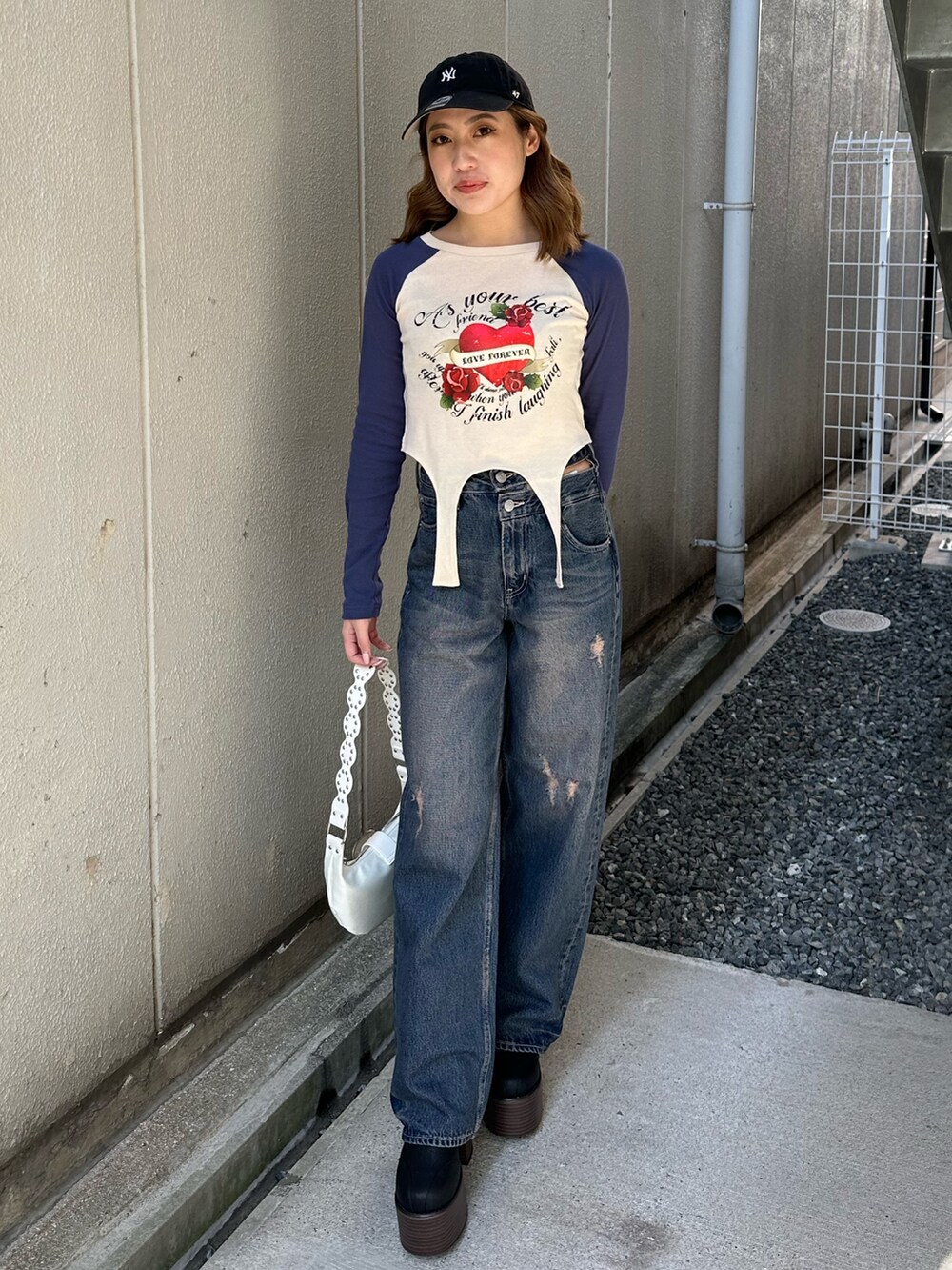 ブルー系のTシャツ/カットソー、ホワイト系のショルダーバッグ、ブルー系のデニムパンツを着用したレディースの春コーディネートの2枚目の写真