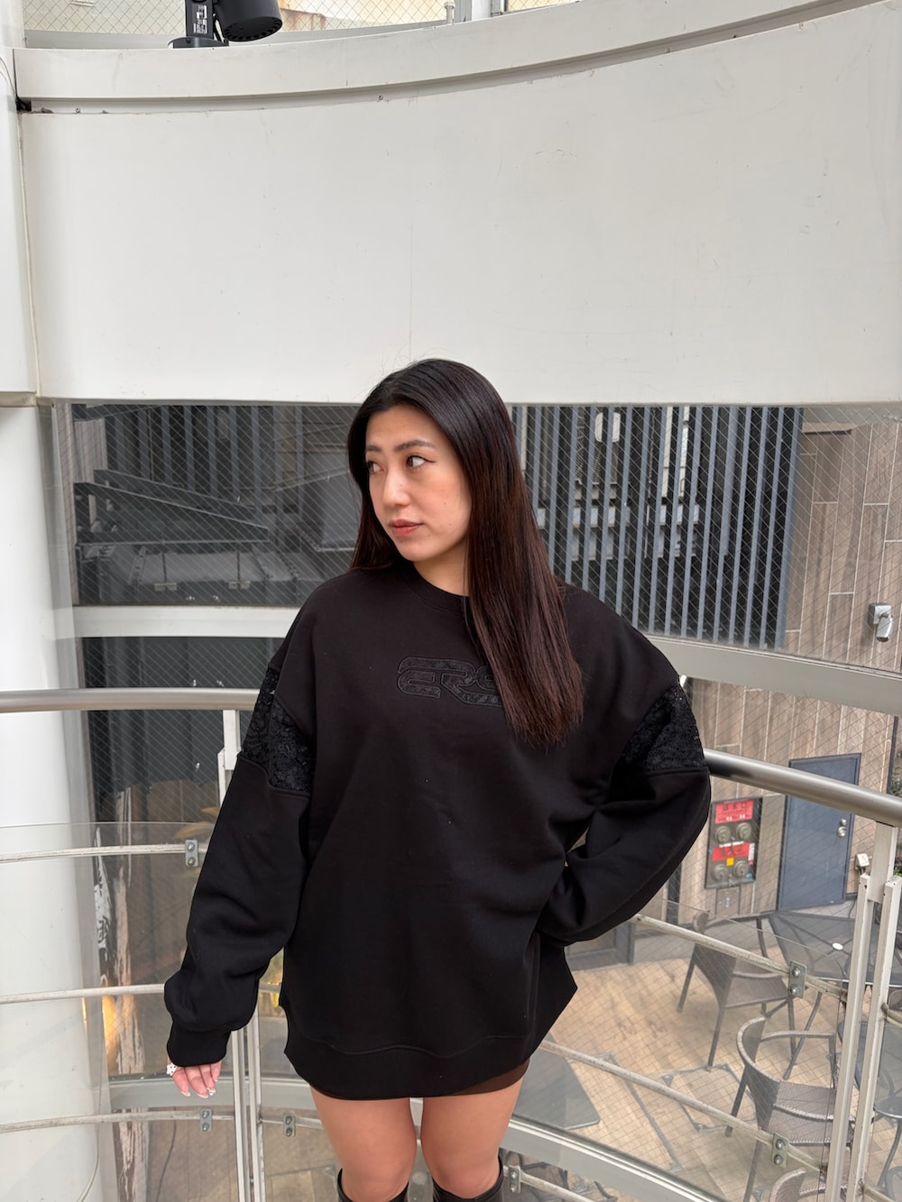 ブラック系のスウェット、ブラック系のブーツを着用したレディースの冬コーディネートの5枚目の写真