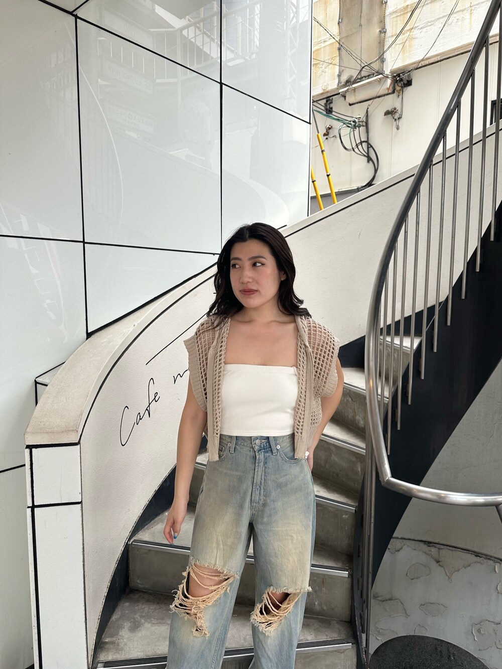 ホワイト系のニット/セーター、ブルー系のデニムパンツ、ブラック系のサンダルを着用したレディースの夏コーディネートの6枚目の写真