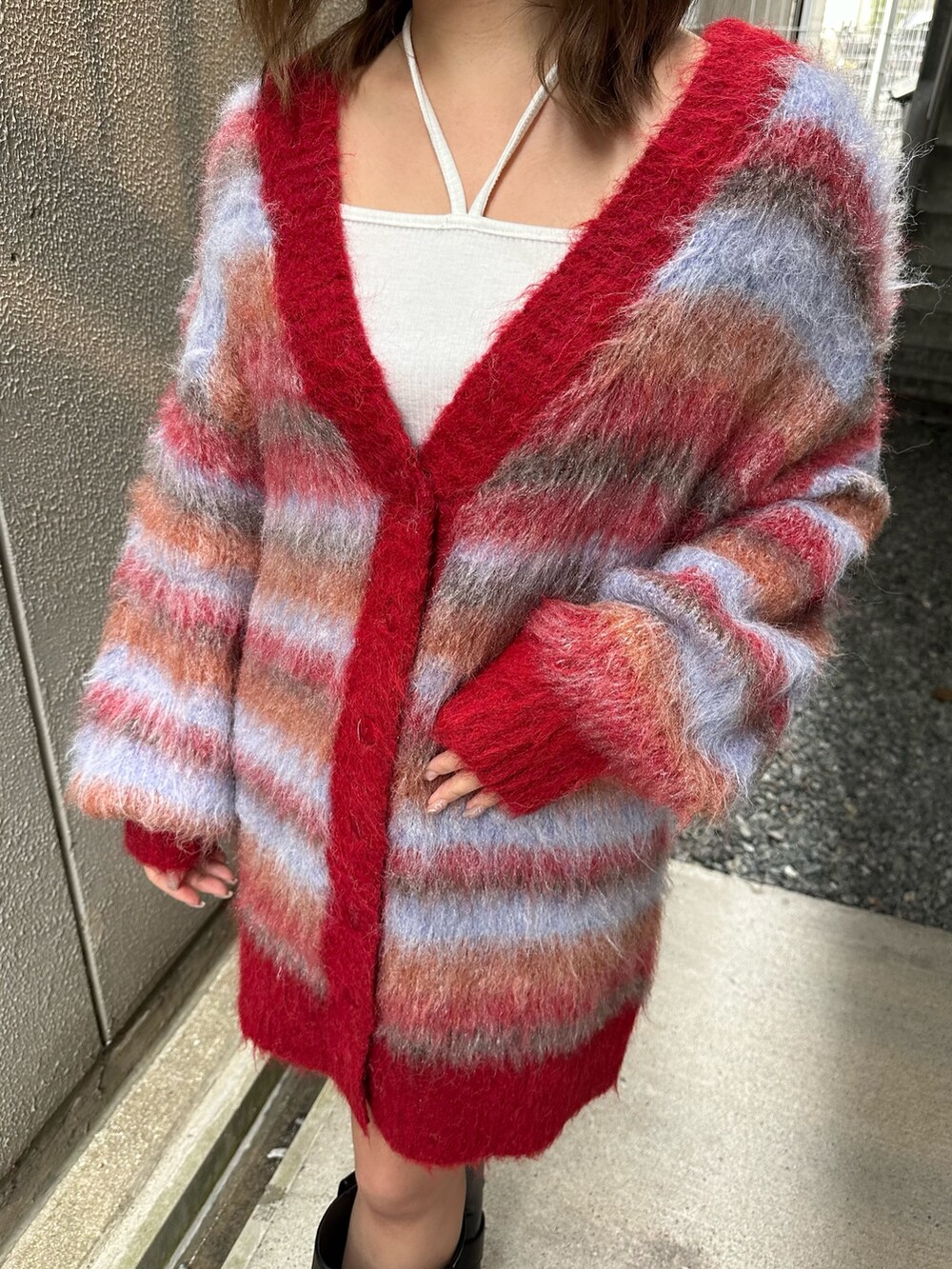 ブラウン系のブーツ、レッド系のカーディガン/ボレロ、ホワイト系のTシャツ/カットソーを着用したレディースの冬コーディネートの5枚目の写真