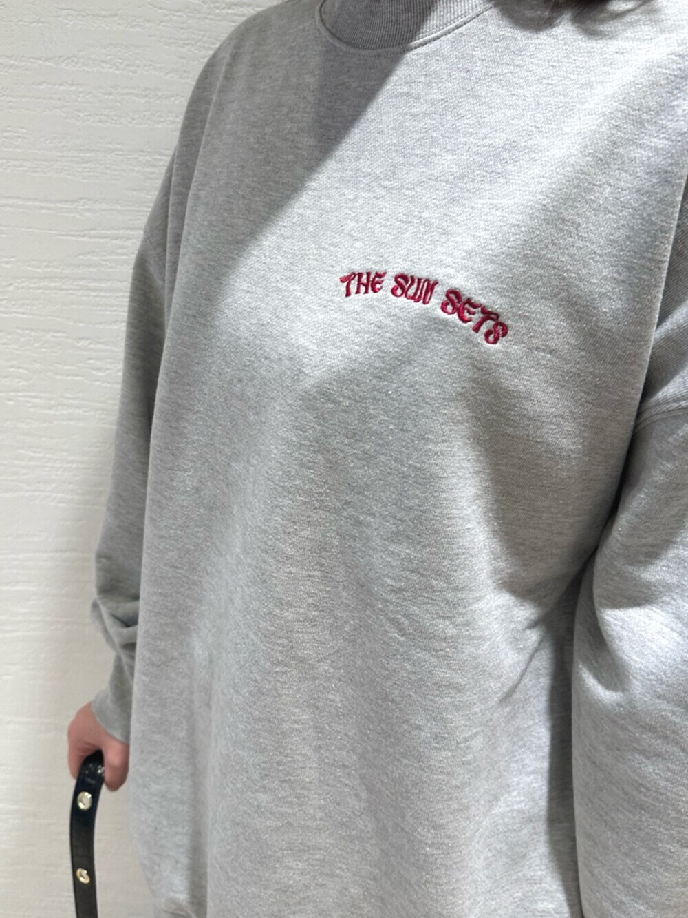 ブラック系のショルダーバッグ、ブラック系のブーツ、グレー系のスウェットを着用したレディースの冬コーディネートの6枚目の写真