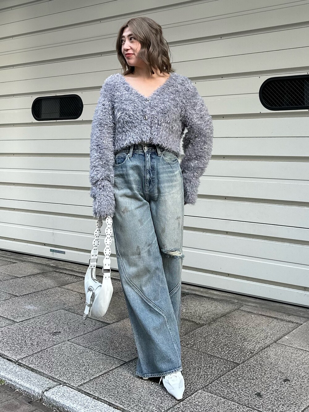 グレー系のカーディガン/ボレロ、ブルー系のデニムパンツを着用したレディースの冬コーディネートの4枚目の写真