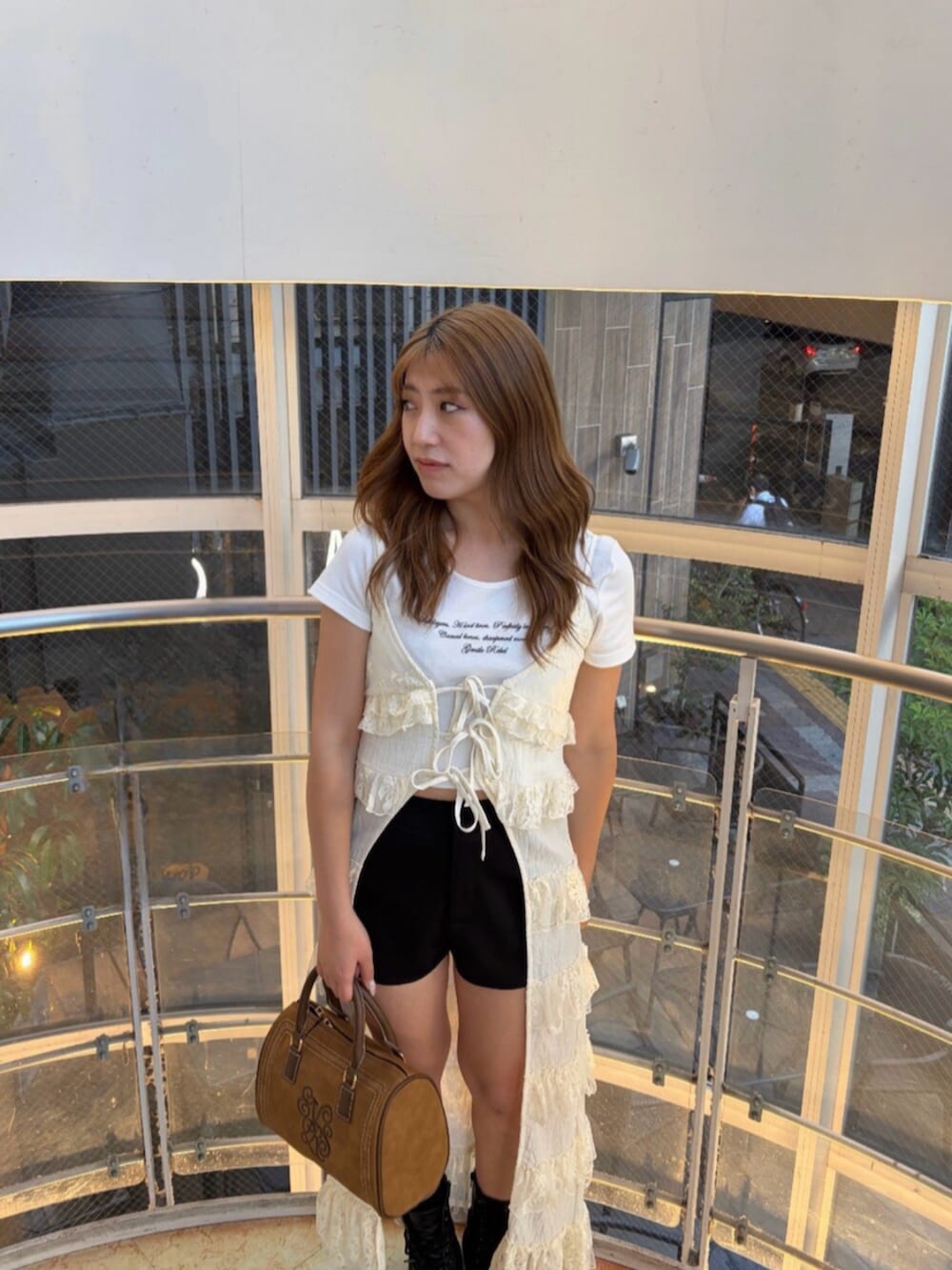 ブラック系のその他パンツ、ブラック系のブーツ、ブラウン系のボストンバッグを着用したレディースの夏コーディネートの4枚目の写真
