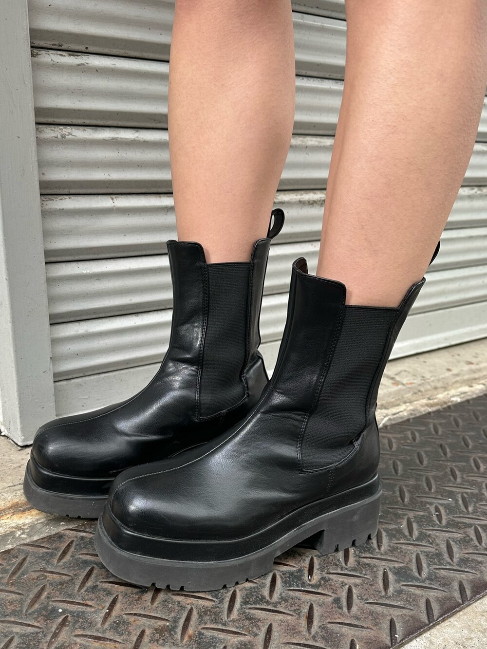 ホワイト系のショルダーバッグ、グリーン系のカーディガン/ボレロ、ブラック系のブーツを着用したレディースの冬コーディネートの7枚目の写真