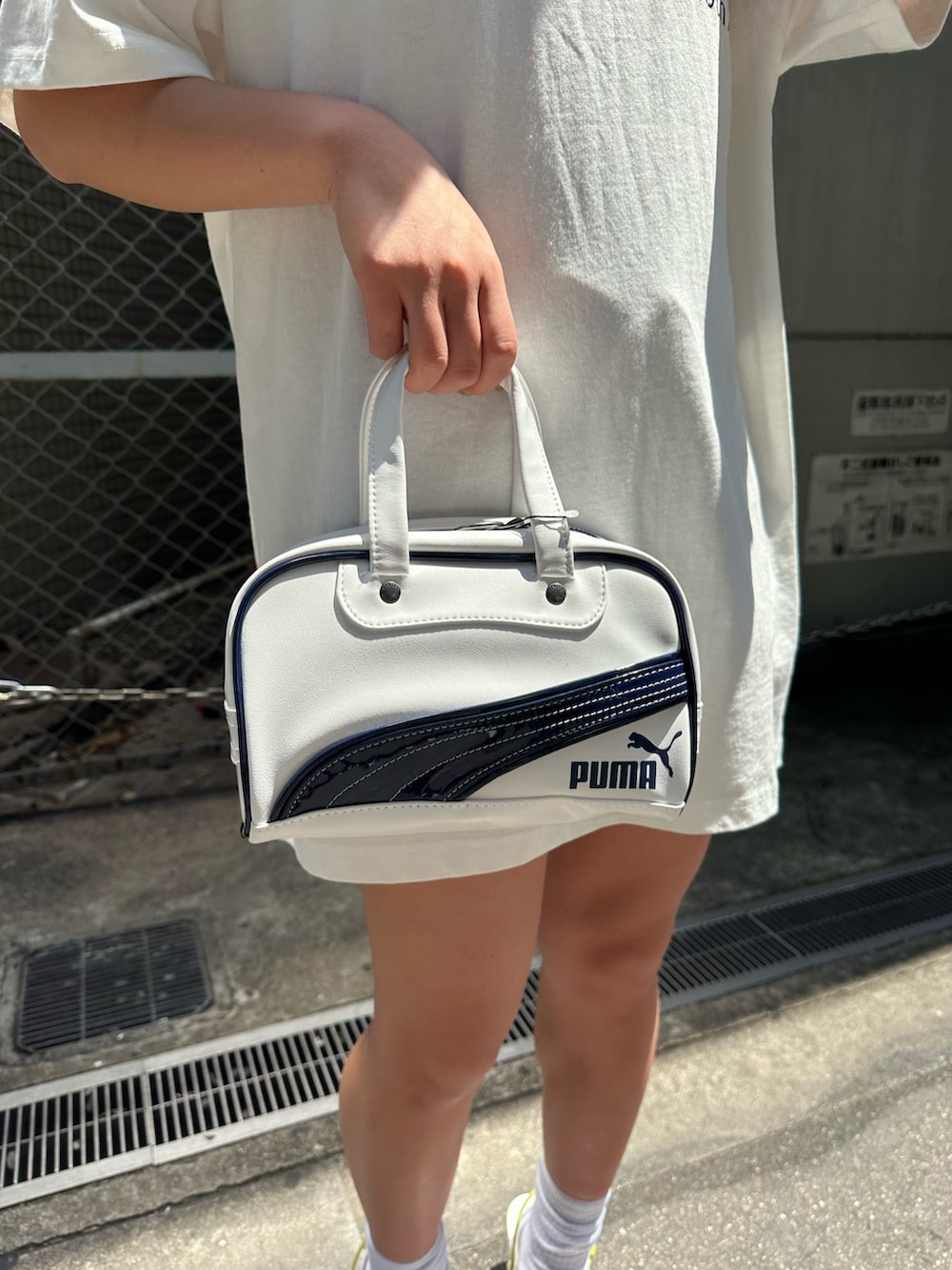 ホワイト系のTシャツ/カットソー、ホワイト系のサンダル、ホワイト系のハンドバッグを着用したレディースの春コーディネートの6枚目の写真