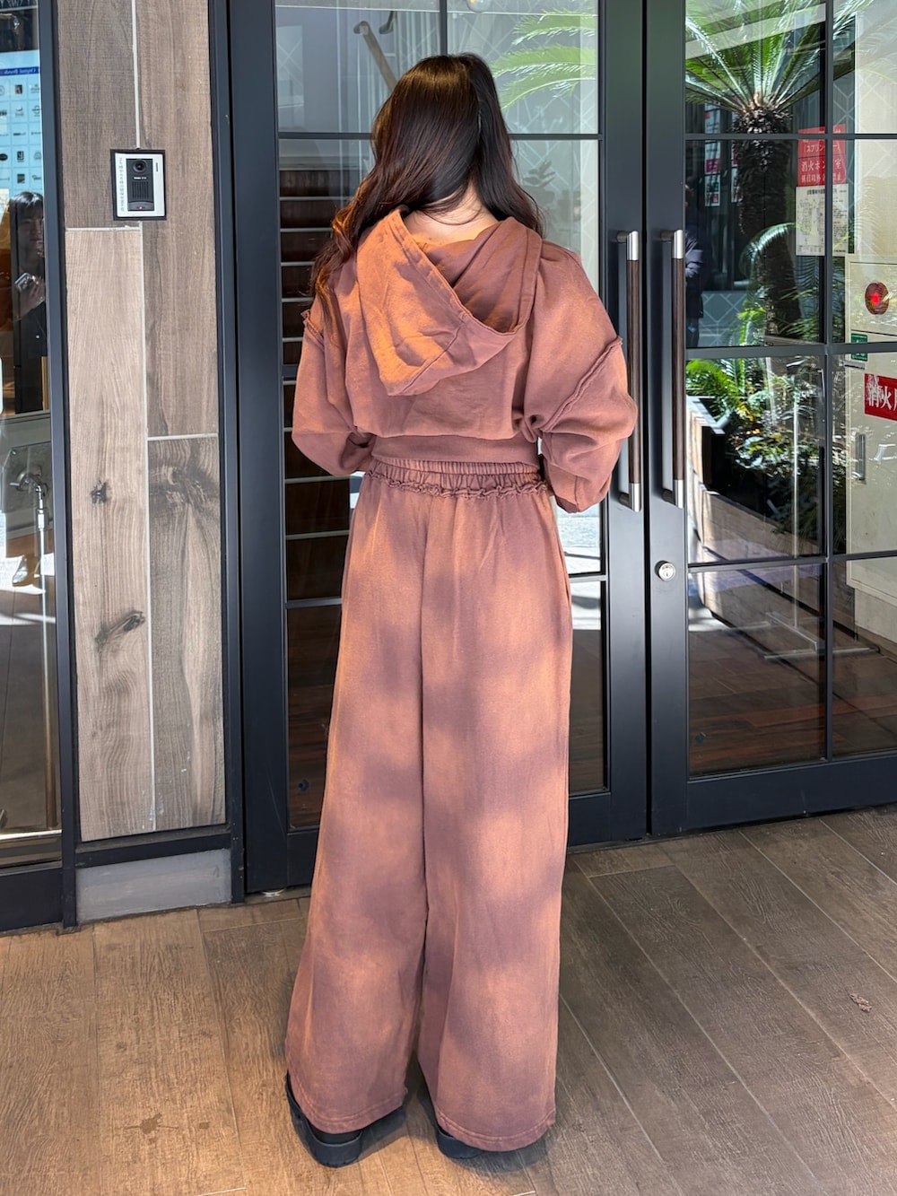 ブラウン系のスウェットパンツ、ブラウン系のパーカー、ブラック系のブーツを着用したレディースの春コーディネートの3枚目の写真