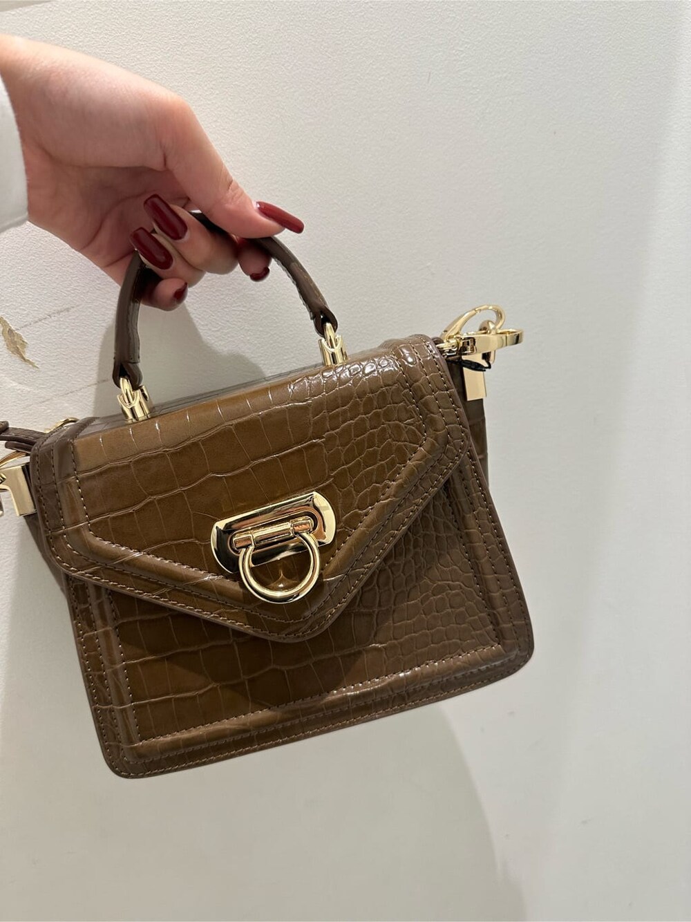 ブラック系のMA-1、ブラウン系のハンドバッグ、ブラック系のデニムパンツを着用したレディースの秋コーディネートの6枚目の写真