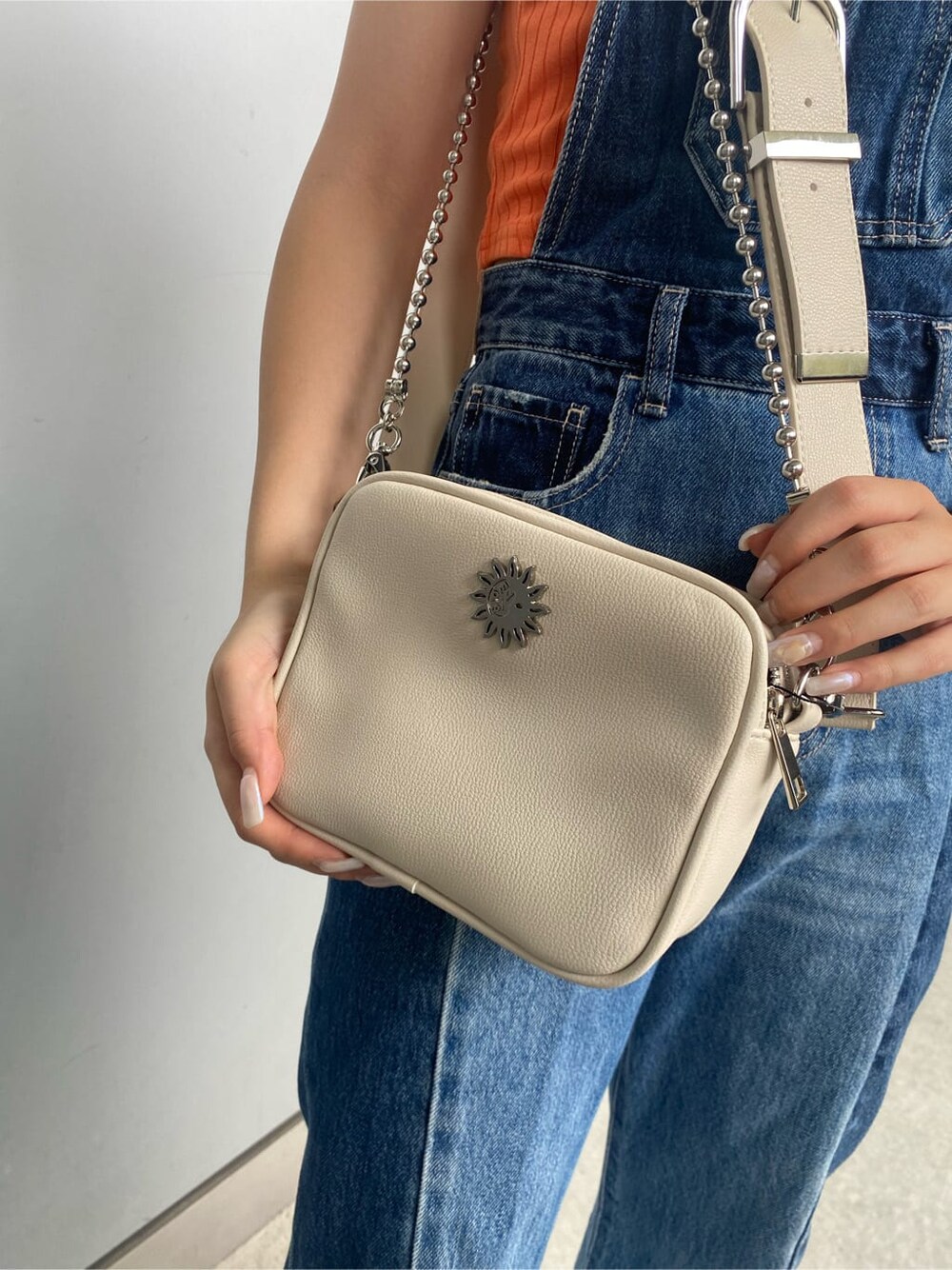 ホワイト系のショルダーバッグ、ブルー系のサロペット/オーバーオール、オレンジ系のタンクトップを着用したレディースの夏コーディネートの6枚目の写真