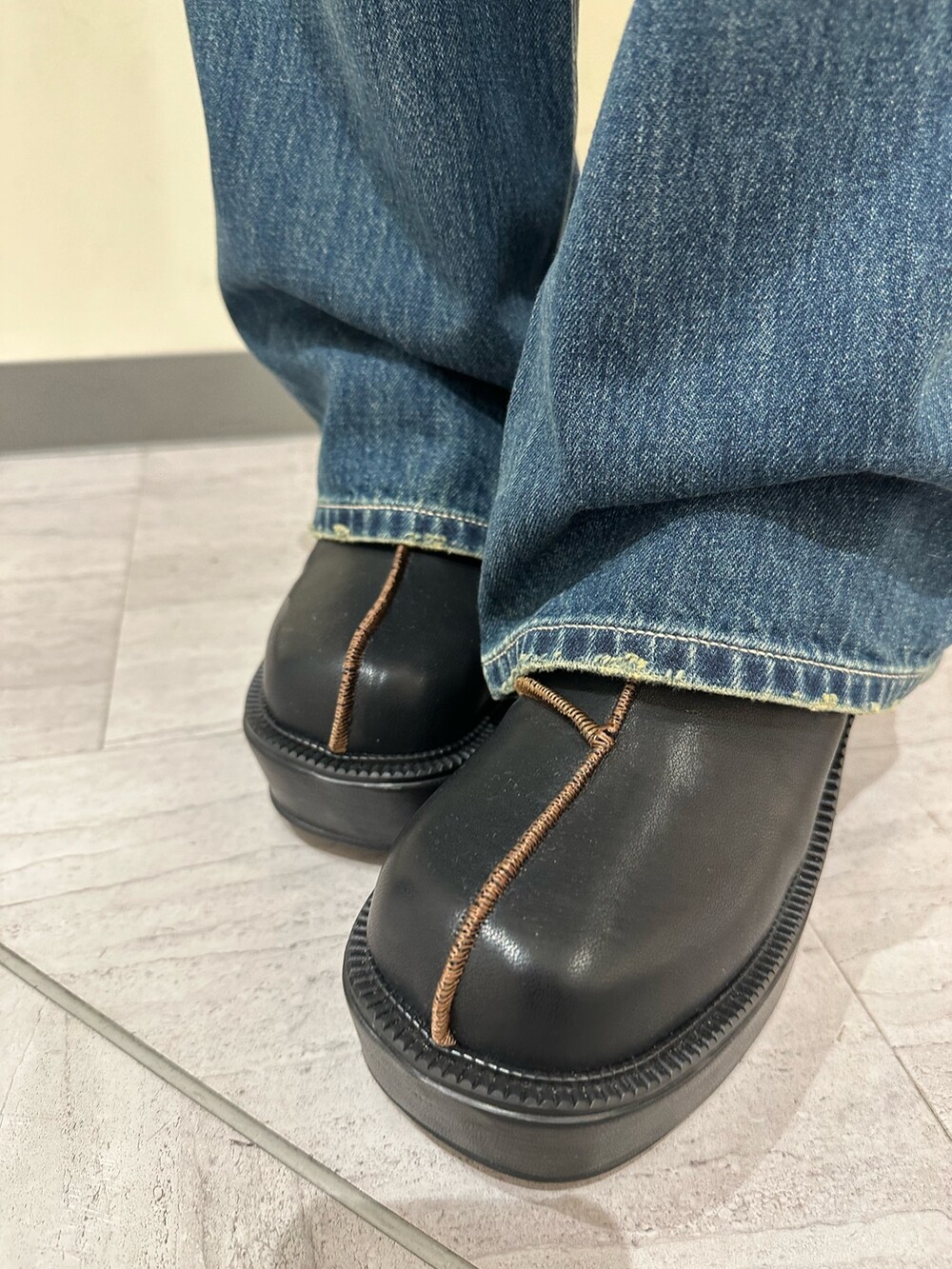 ブルー系のデニムパンツ、グレー系のTシャツ/カットソー、ブラック系のブーツを着用したレディースの冬コーディネートの7枚目の写真