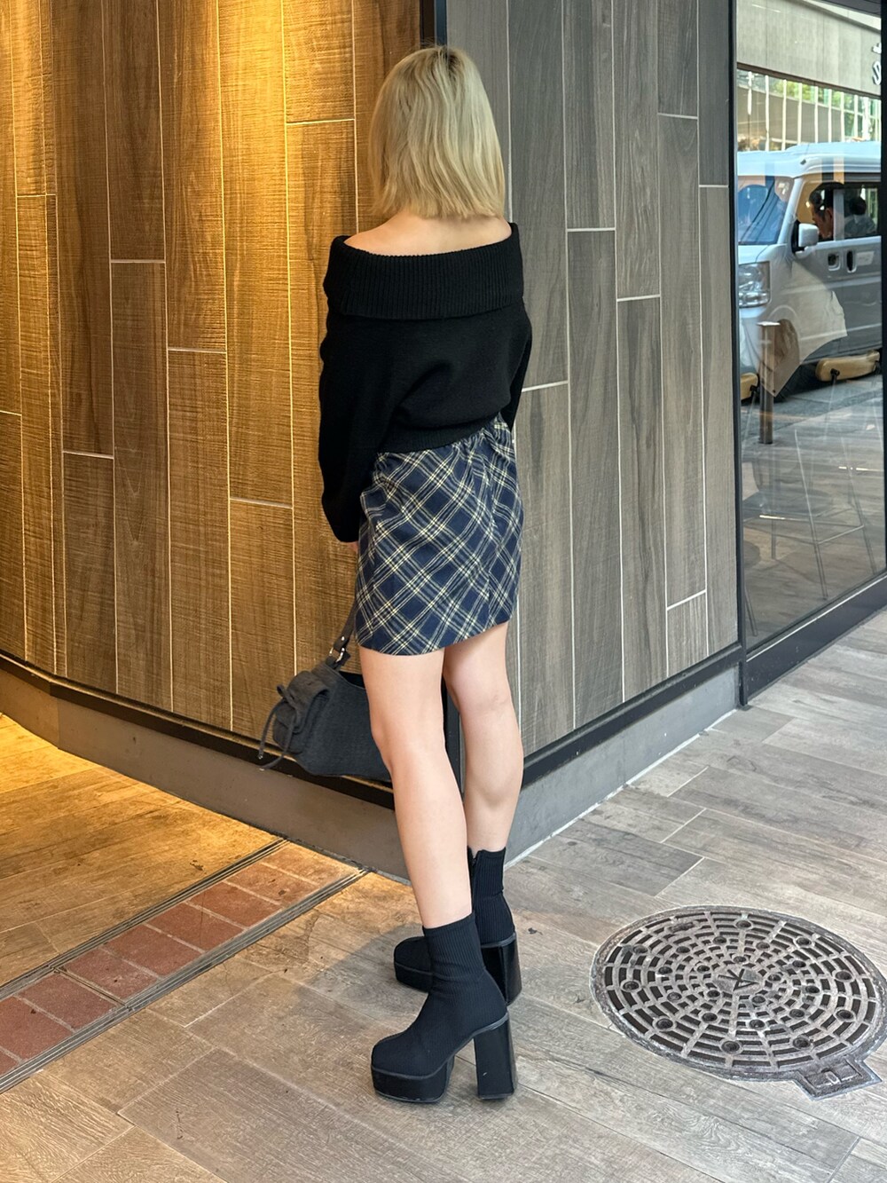 ブラック系のニット/セーター、その他のブーツ、ブラック系のハンドバッグを着用したレディースの秋コーディネートの3枚目の写真