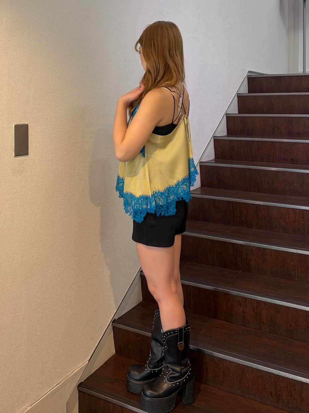 ブラック系のその他パンツ、ブラック系のブーツ、イエロー系のキャミソールを着用したレディースの春コーディネートの3枚目の写真