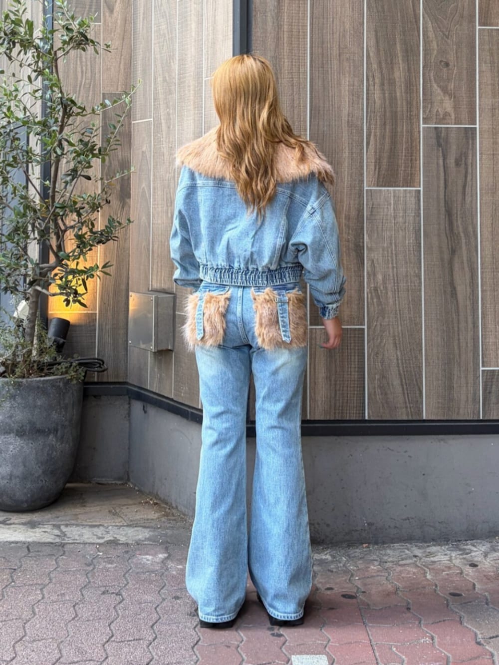 ブラック系のブーツ、ブルー系のデニムパンツ、ブルー系のブルゾンを着用したレディースの夏コーディネートの3枚目の写真