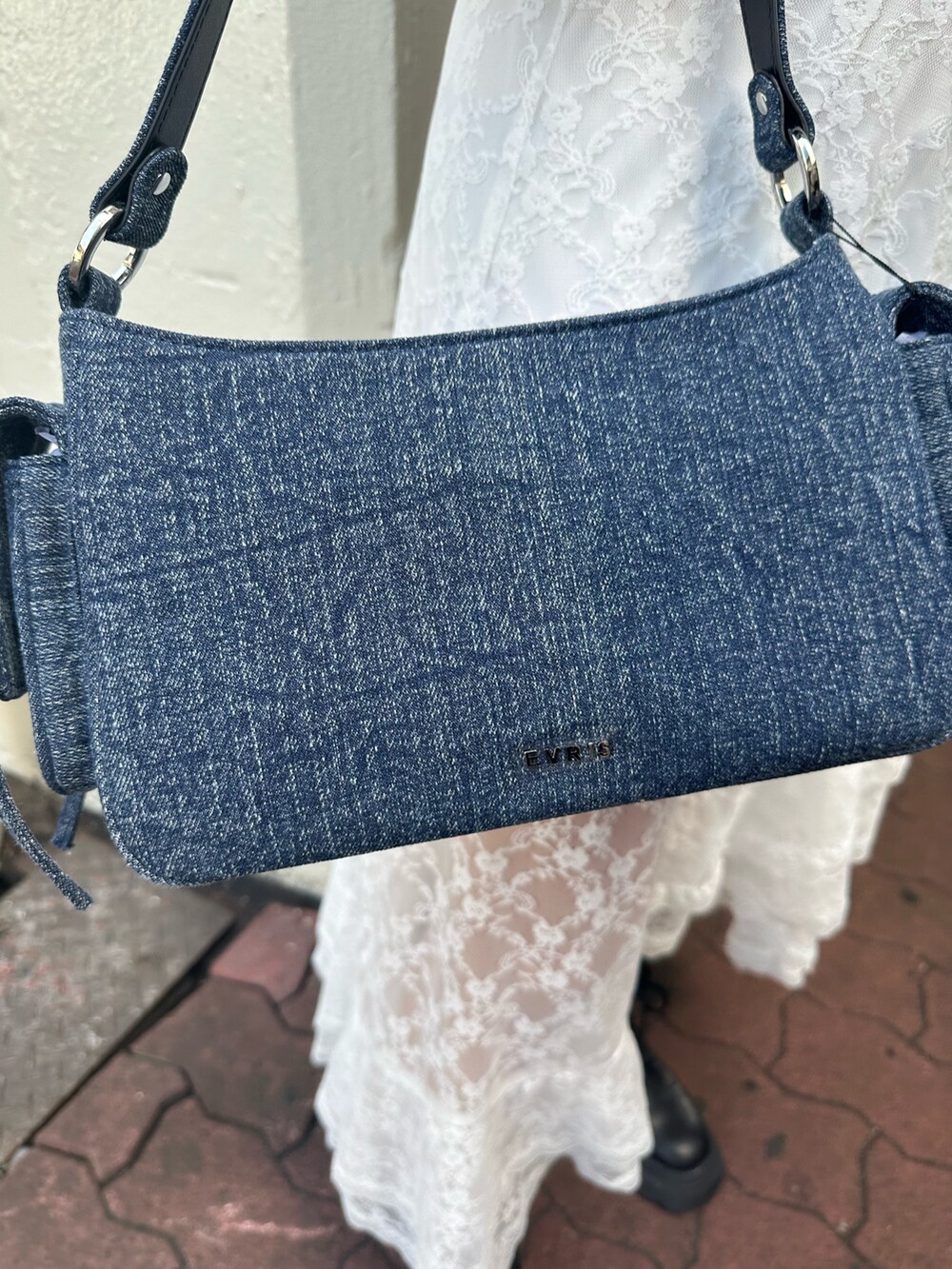 ホワイト系のスカート、グレー系のスウェット、ブラック系のブーツを着用したレディースの秋コーディネートの8枚目の写真