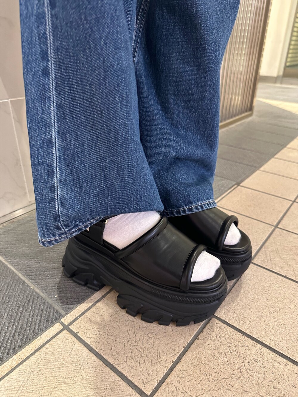 ホワイト系のシャツ/ブラウス、ブルー系のデニムパンツ、ブラック系のサンダルを着用したレディースの春コーディネートの7枚目の写真