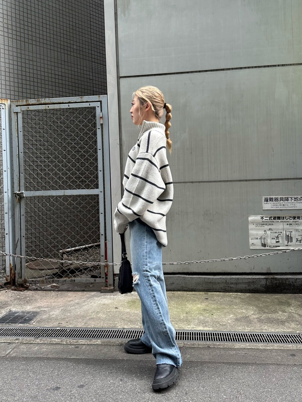 ブラック系のデニムパンツ、ブラック系のハンドバッグ、その他のニット/セーターを着用したレディースの夏コーディネートの2枚目の写真