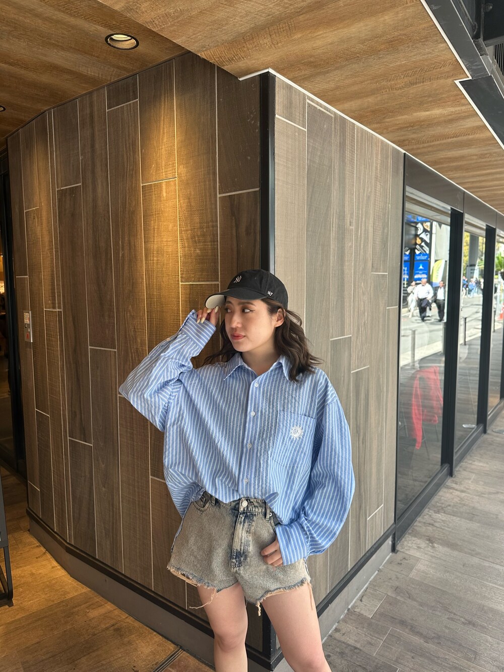 ブルー系のシャツ/ブラウス、ブラック系のブーツ、ベージュ系のデニムパンツを着用したレディースの春コーディネートの4枚目の写真