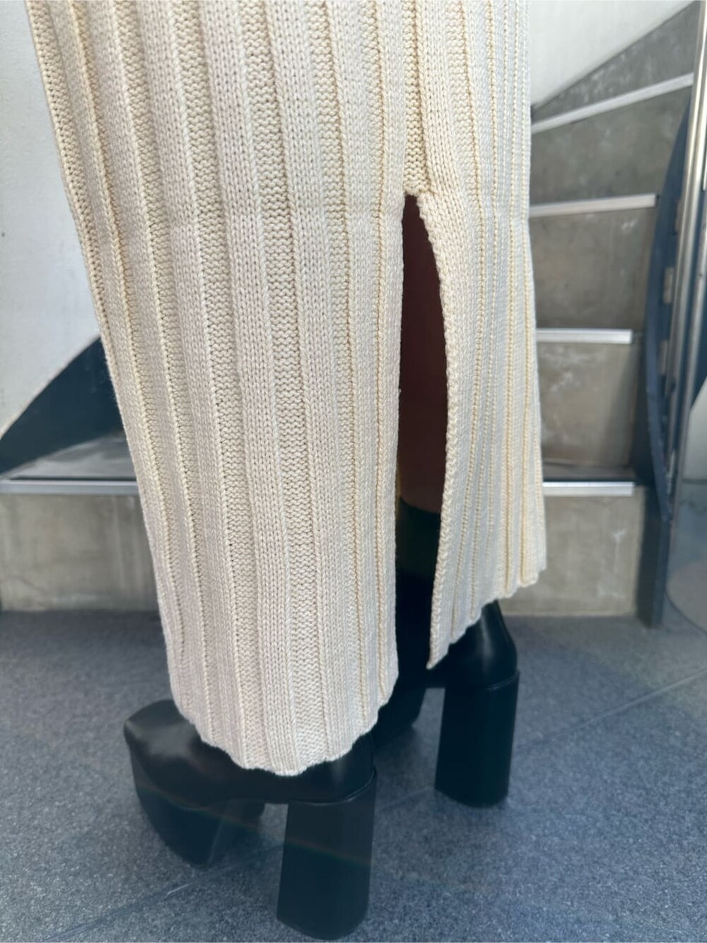 ホワイト系のスカート、ホワイト系のニット/セーター、ブラック系のハンドバッグを着用したレディースの秋コーディネートの7枚目の写真