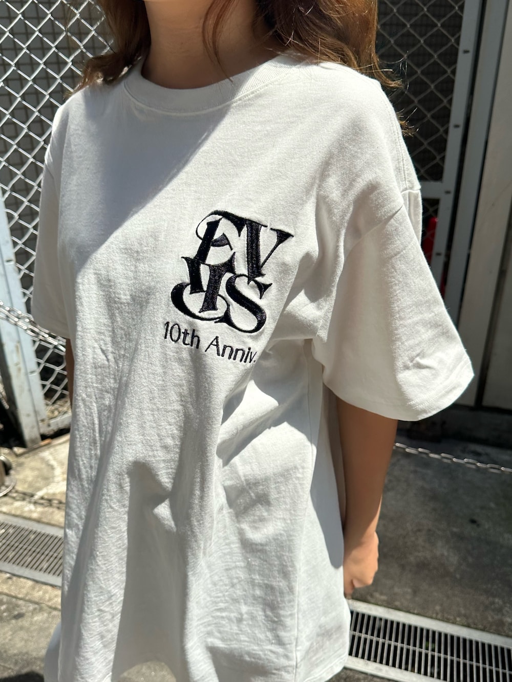 ホワイト系のTシャツ/カットソー、ホワイト系のサンダル、ホワイト系のハンドバッグを着用したレディースの春コーディネートの4枚目の写真