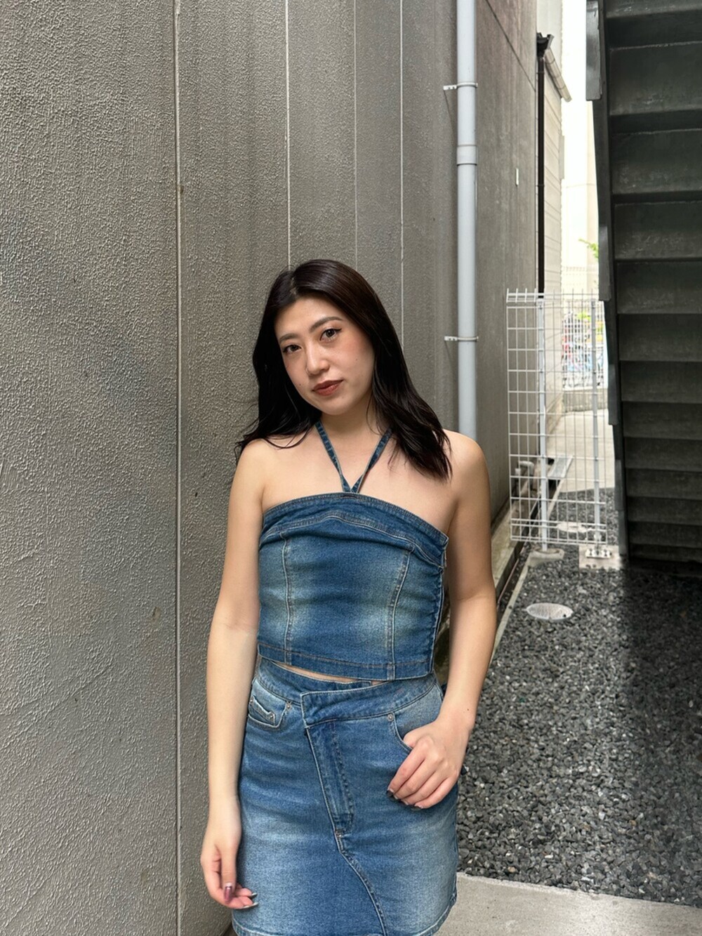 ブラック系のサンダル、ブルー系のキャミソール、ブルー系のデニムスカートを着用したレディースの夏コーディネートの4枚目の写真