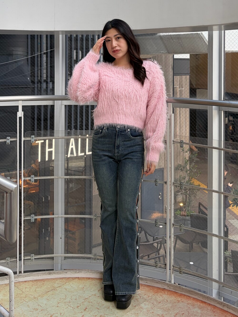 ブルー系のデニムパンツ、ピンク系のニット/セーター、ブラック系のブーツを着用したレディースの冬コーディネートの2枚目の写真