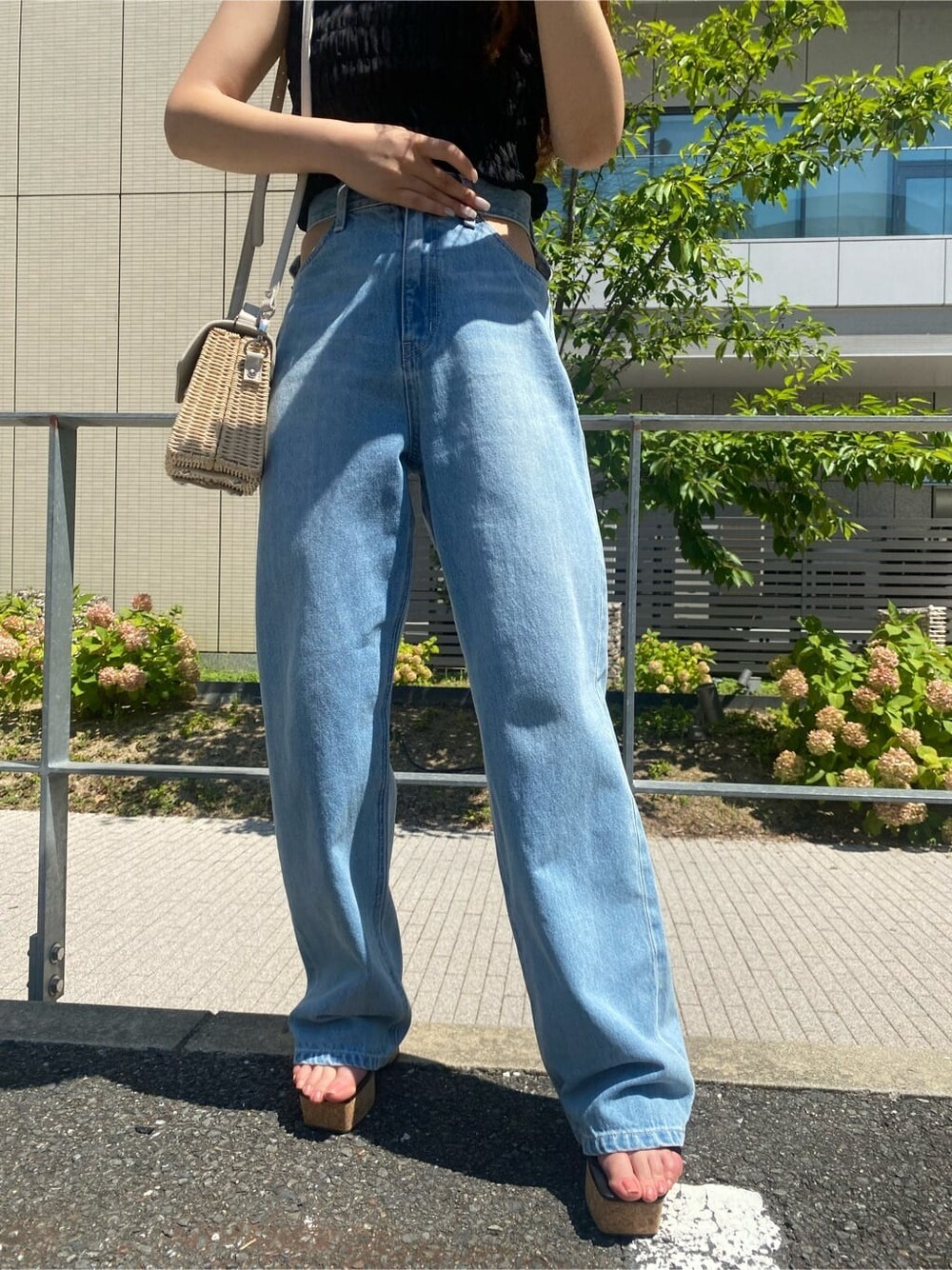 ブルー系のデニムパンツ、ブラック系のサンダル、ホワイト系のショルダーバッグを着用したレディースの夏コーディネートの5枚目の写真