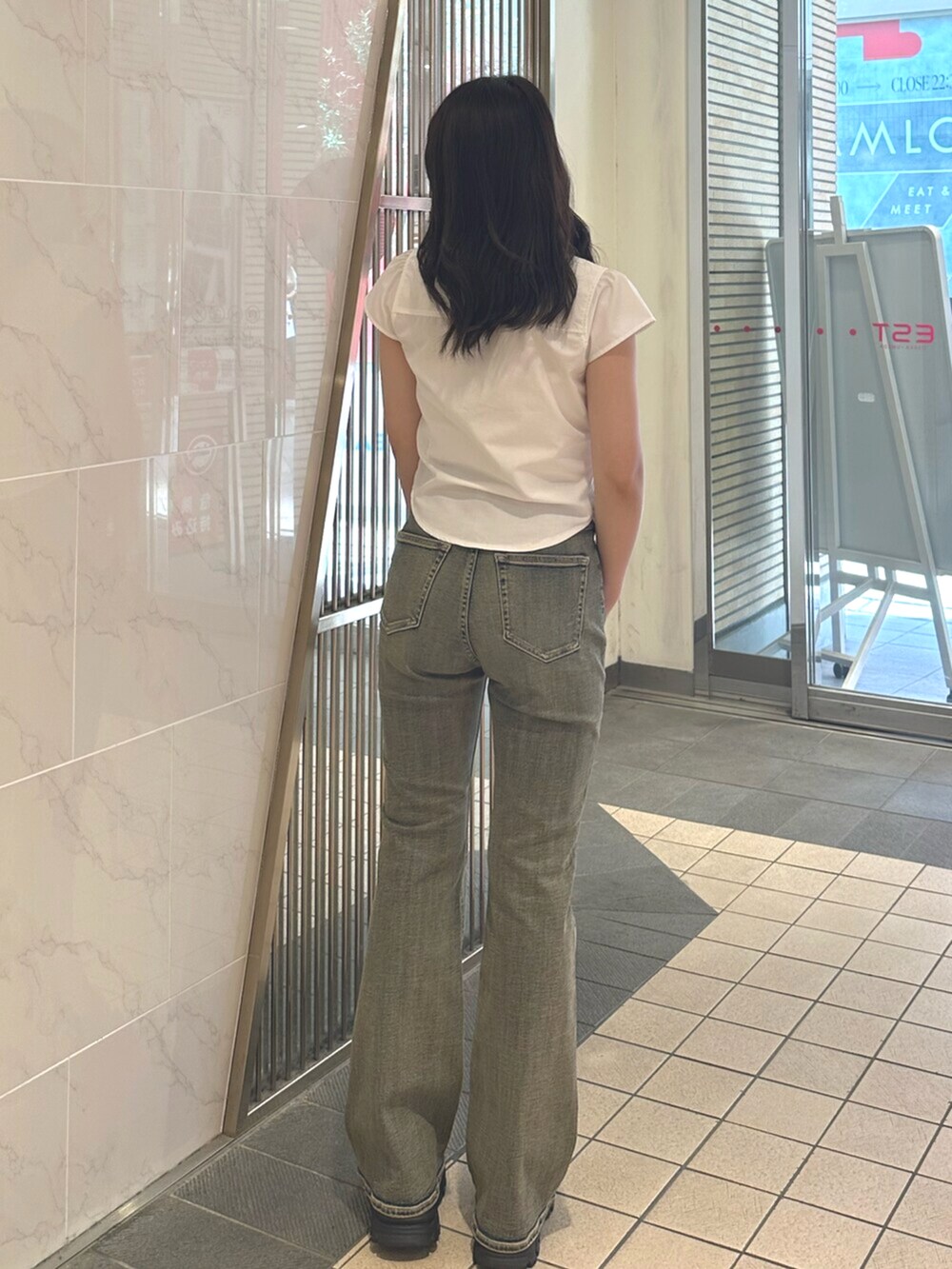 ブラック系のサンダル、ブルー系のデニムパンツ、ホワイト系のシャツ/ブラウスを着用したレディースの夏コーディネートの3枚目の写真