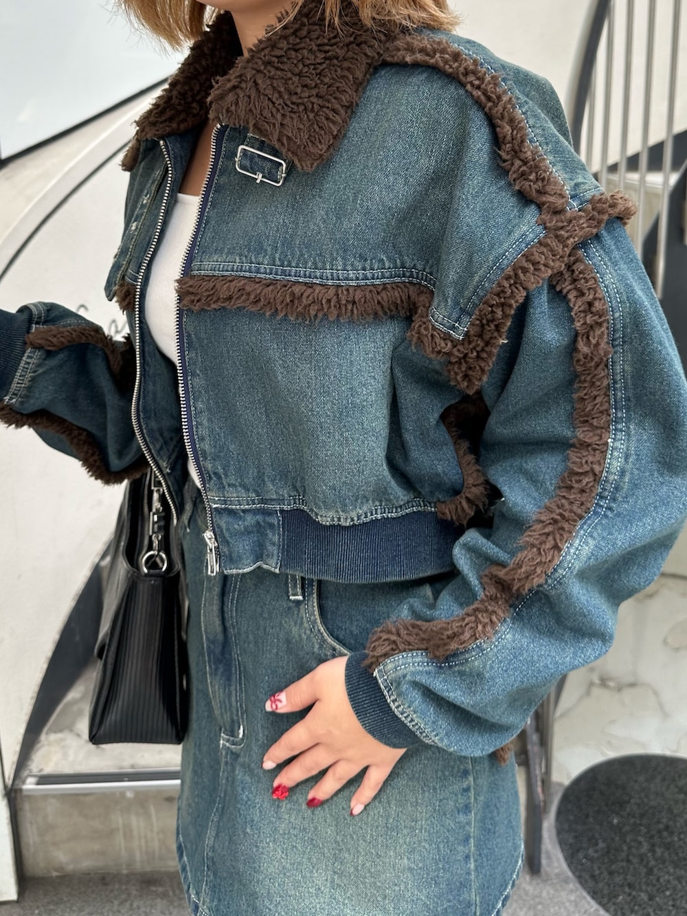 ブルー系のブルゾン、ブルー系のデニムスカート、その他のブーツを着用したレディースの秋コーディネートの5枚目の写真