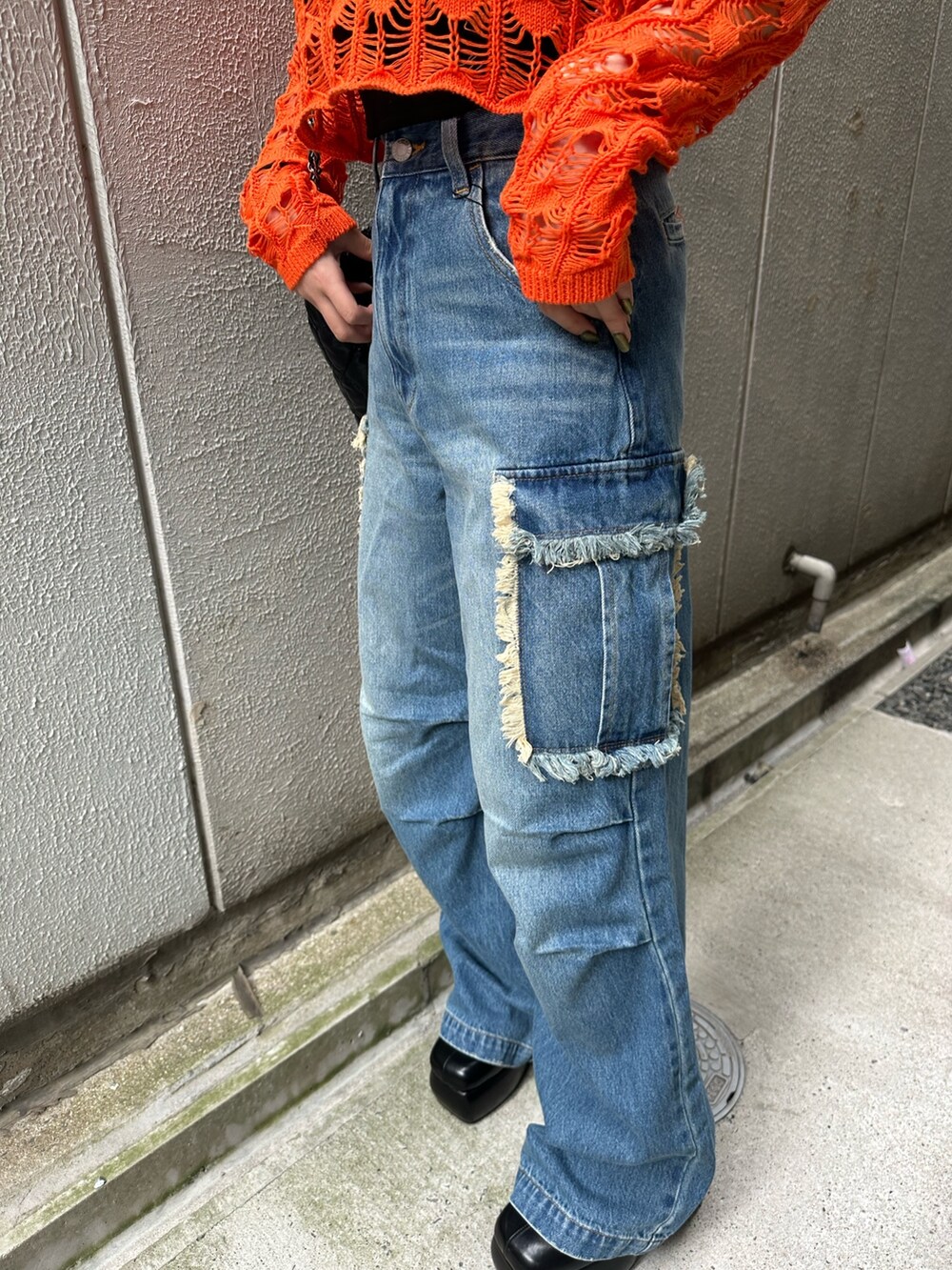 ブラック系のショルダーバッグ、ブラック系のサンダル、ブルー系のデニムパンツを着用したレディースの春コーディネートの7枚目の写真