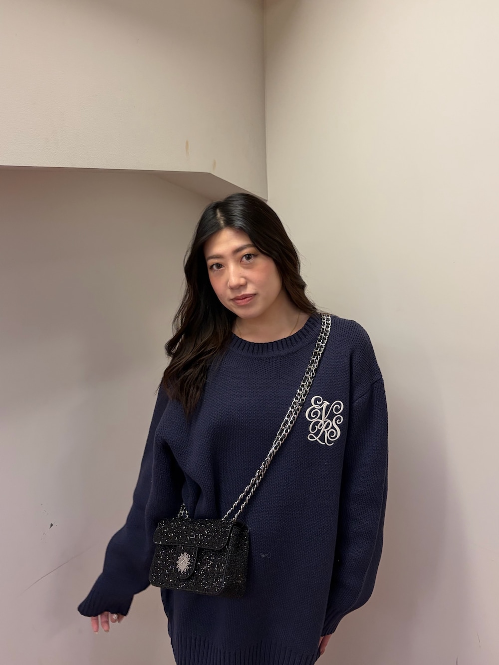 ブラック系のブーツ、ブラック系のショルダーバッグ、ブルー系のニット/セーターを着用したレディースの冬コーディネートの4枚目の写真