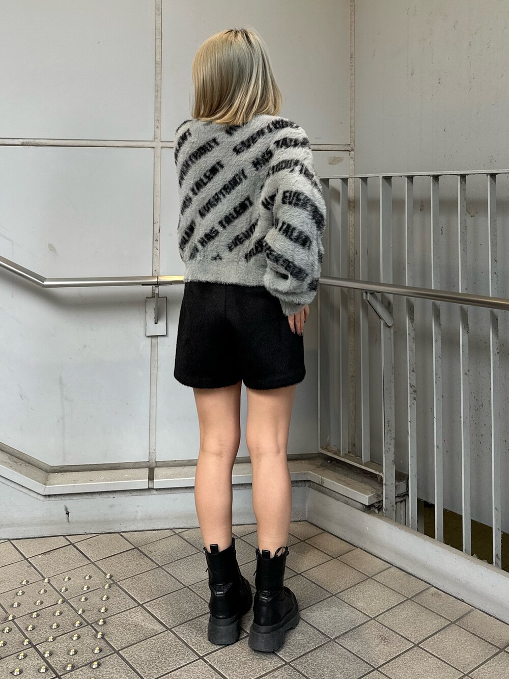 ブラック系のその他パンツ、ブラック系のブーツ、グレー系のニット/セーターを着用したレディースの冬コーディネートの3枚目の写真