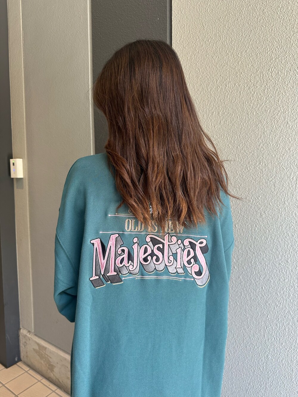 ブルー系のスウェット、ブラック系のブーツ、ブルー系のデニムパンツを着用したレディースの秋コーディネートの5枚目の写真