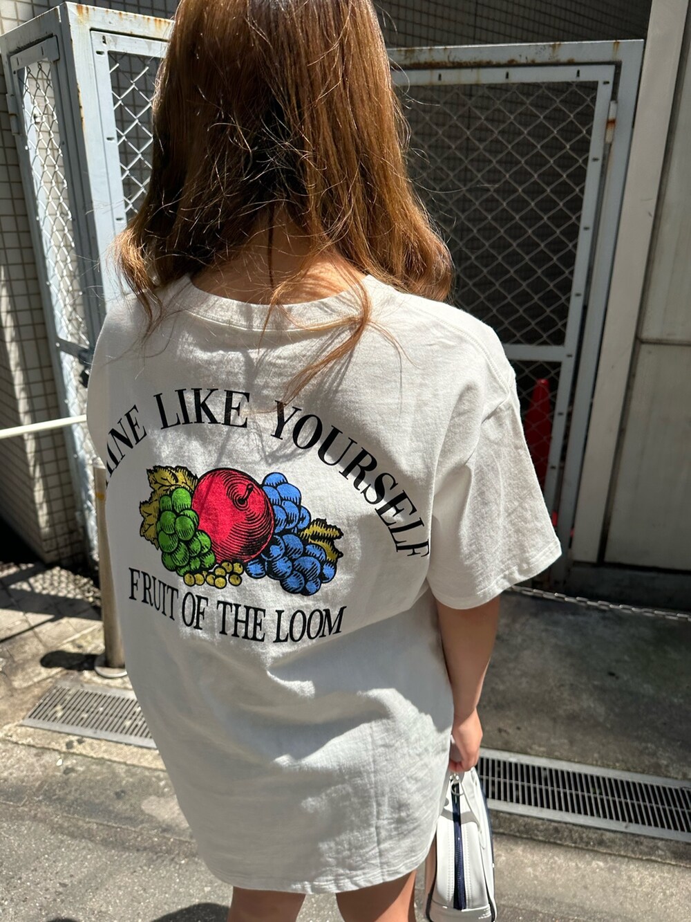 ホワイト系のTシャツ/カットソー、ホワイト系のサンダル、ホワイト系のハンドバッグを着用したレディースの春コーディネートの5枚目の写真