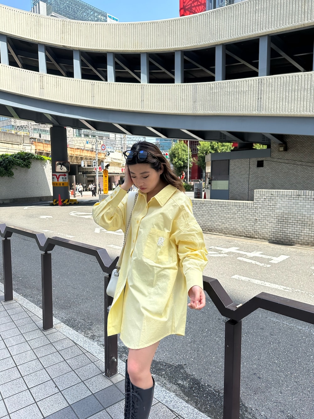 イエロー系のシャツ/ブラウス、ブラック系のブーツ、ホワイト系のショルダーバッグを着用したレディースの春コーディネートの4枚目の写真