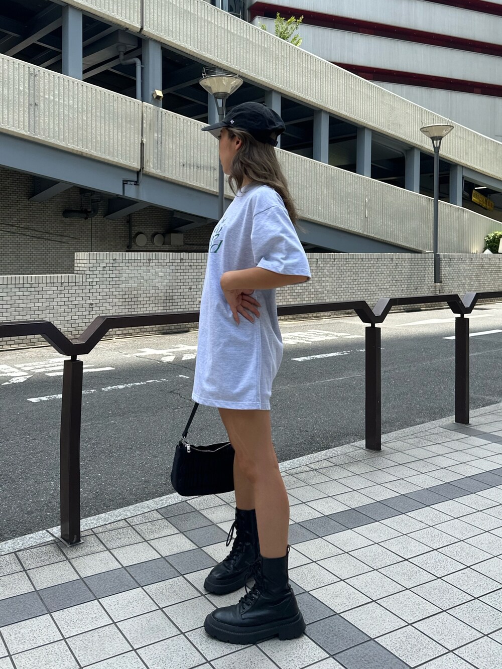 グレー系のTシャツ/カットソー、ブラック系のハンドバッグ、ブラック系のブーツを着用したレディースの夏コーディネートの2枚目の写真