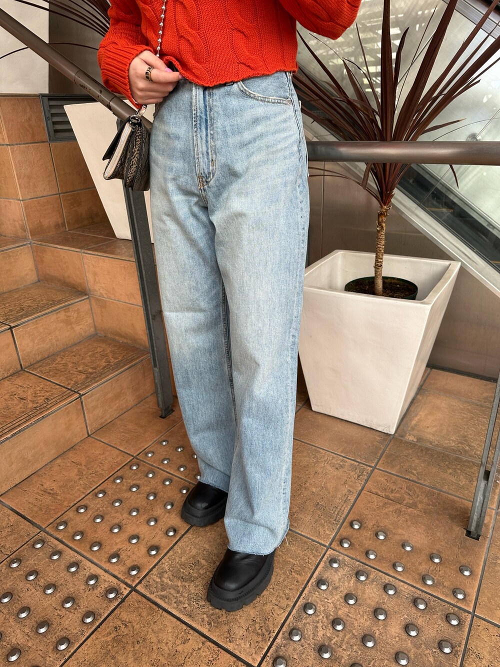 オレンジ系のカーディガン/ボレロ、ホワイト系のシャツ/ブラウス、ブルー系のデニムパンツを着用したレディースの冬コーディネートの7枚目の写真