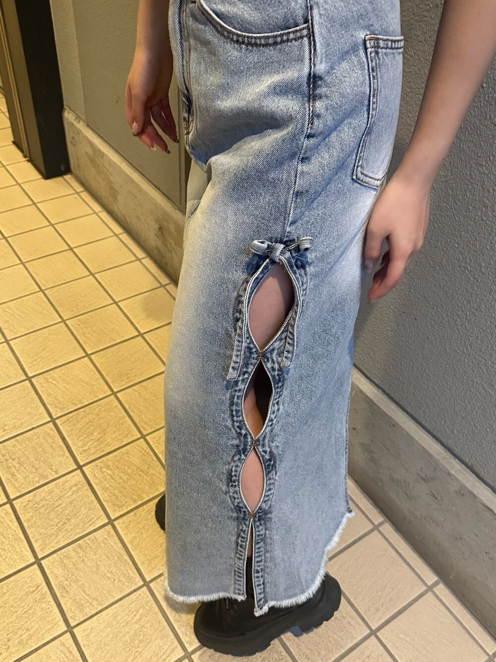 ブルー系のデニムスカート、その他のハンドバッグ、ブラック系のブーツを着用したレディースの春コーディネートの6枚目の写真