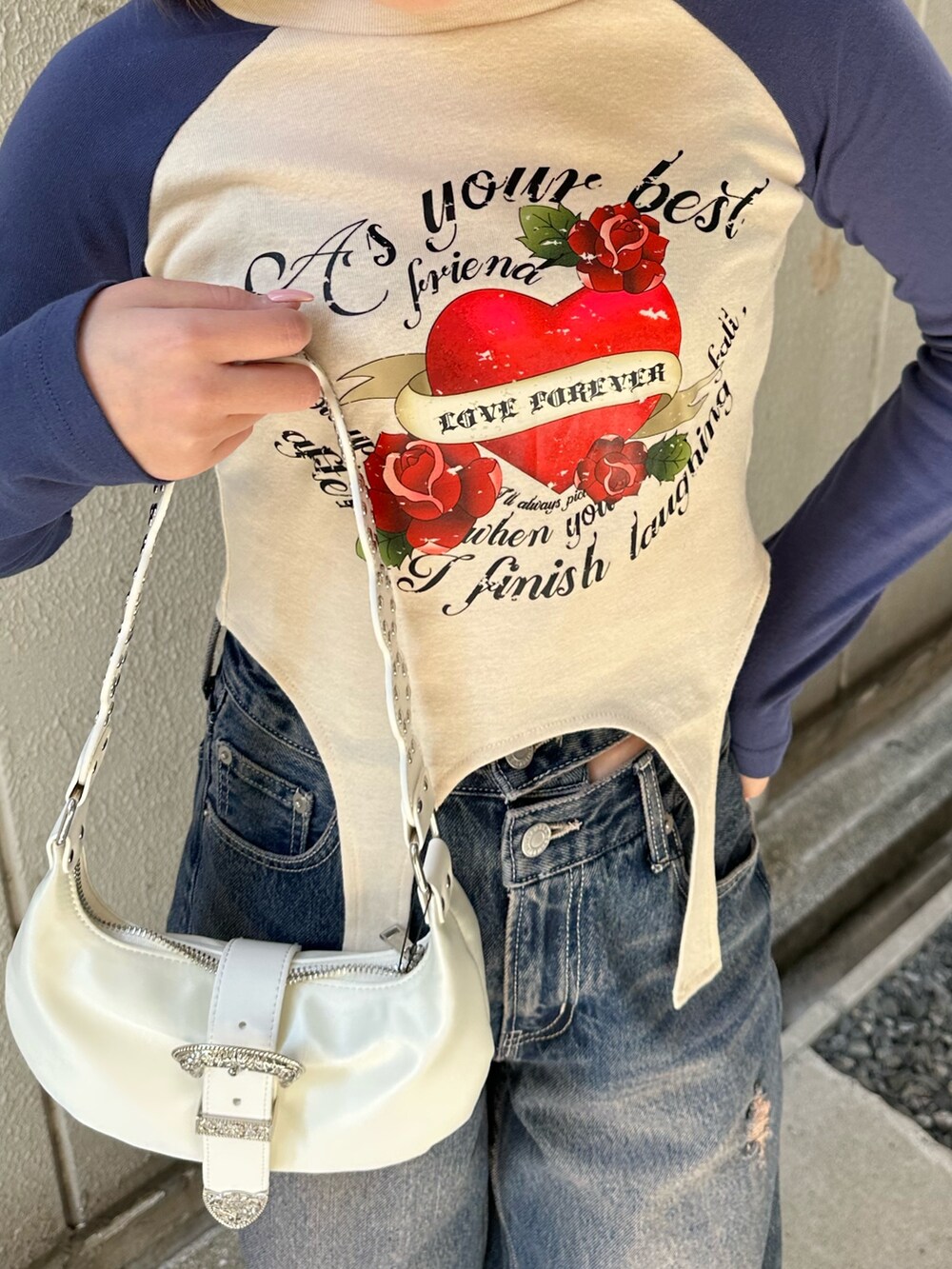 ブルー系のTシャツ/カットソー、ホワイト系のショルダーバッグ、ブルー系のデニムパンツを着用したレディースの春コーディネートの6枚目の写真