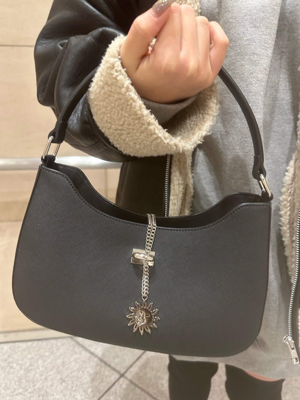 グレー系のスウェット、ブラック系のブルゾン、ブラック系のハンドバッグを着用したレディースの冬コーディネートの8枚目の写真