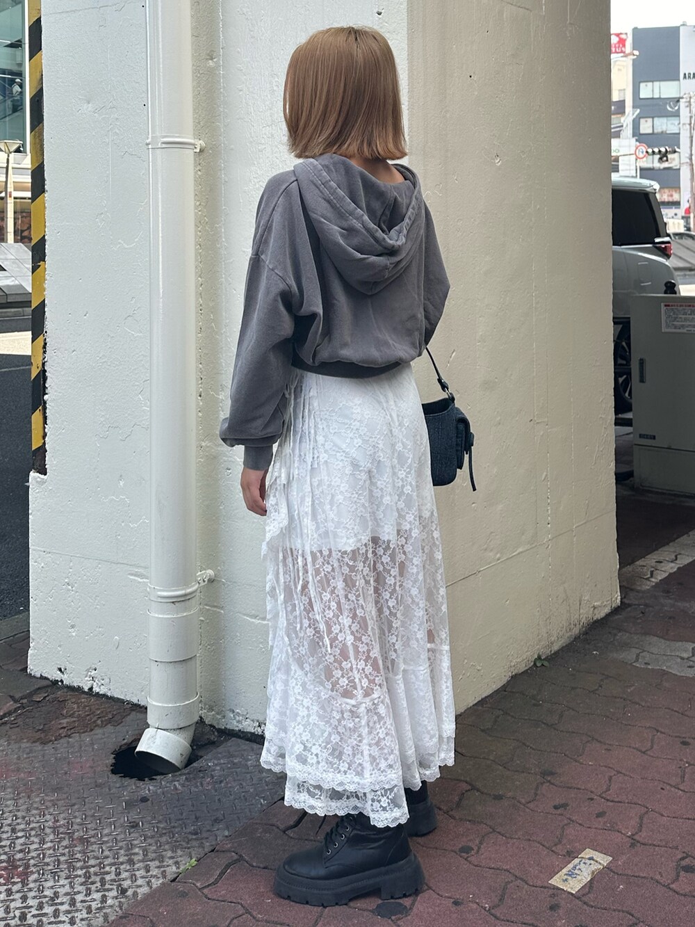 ホワイト系のスカート、グレー系のスウェット、ブラック系のブーツを着用したレディースの秋コーディネートの3枚目の写真