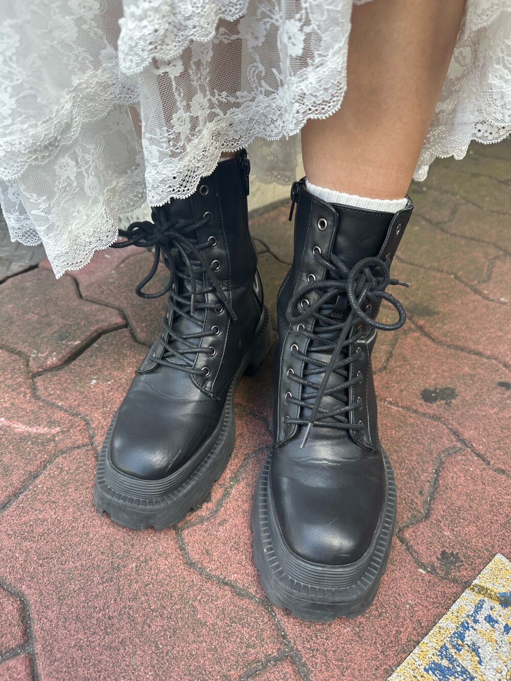 ホワイト系のスカート、グレー系のスウェット、ブラック系のブーツを着用したレディースの秋コーディネートの10枚目の写真