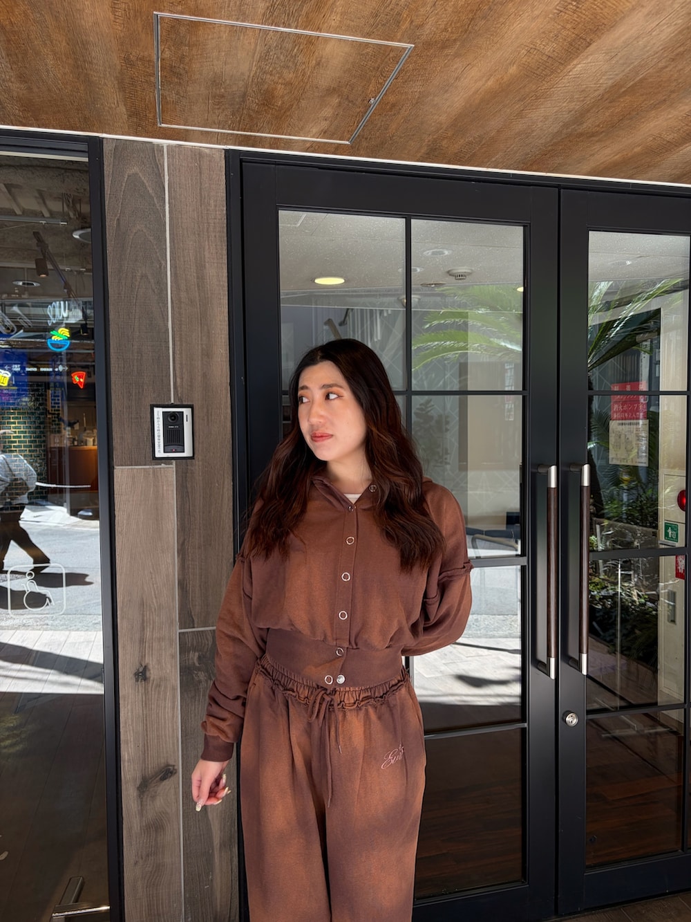 ブラウン系のスウェットパンツ、ブラウン系のパーカー、ブラック系のブーツを着用したレディースの春コーディネートの5枚目の写真