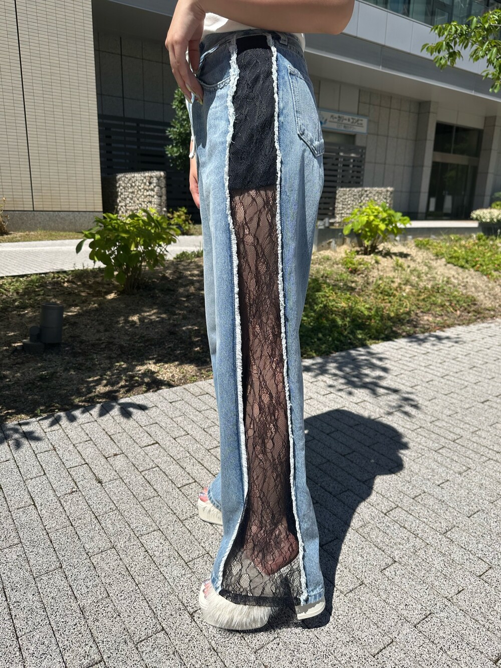 ホワイト系のタンクトップ、ホワイト系のサンダル、ブルー系のデニムパンツを着用したレディースの夏コーディネートの7枚目の写真